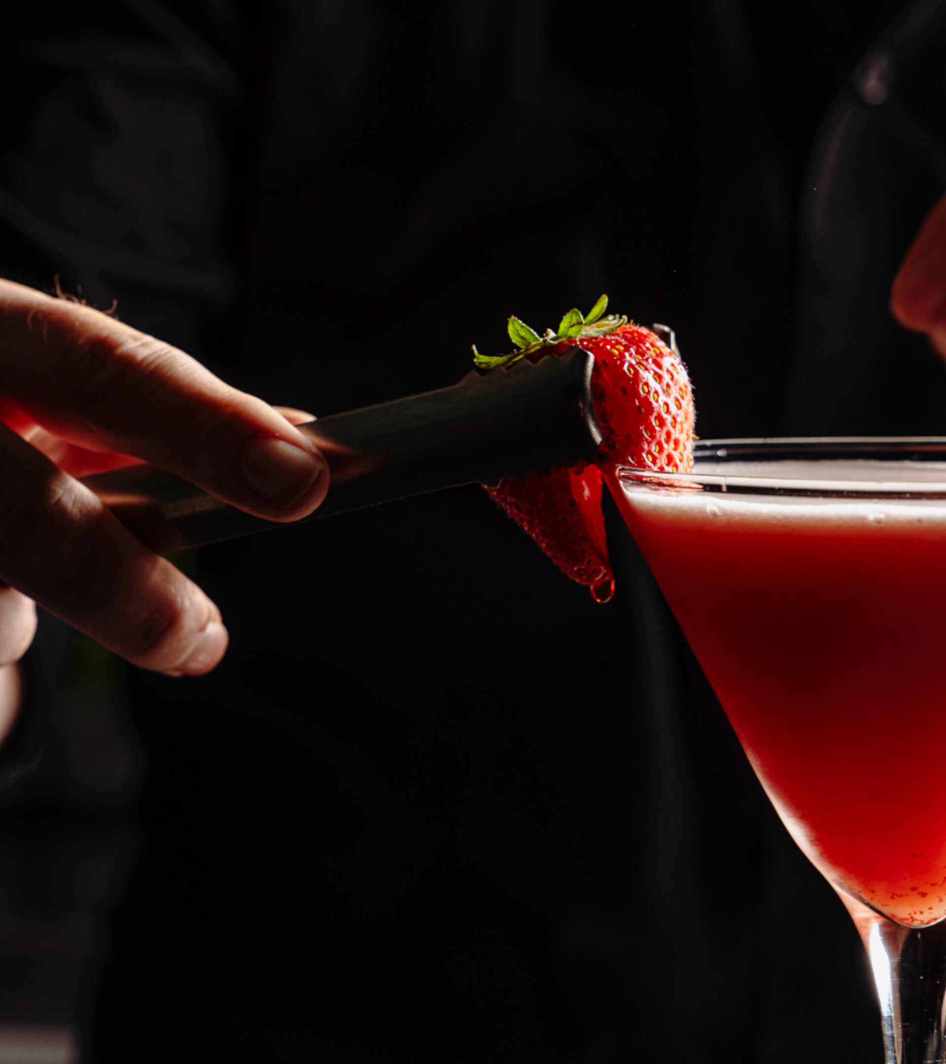 Red coloured cocktail with raspberry decoration.