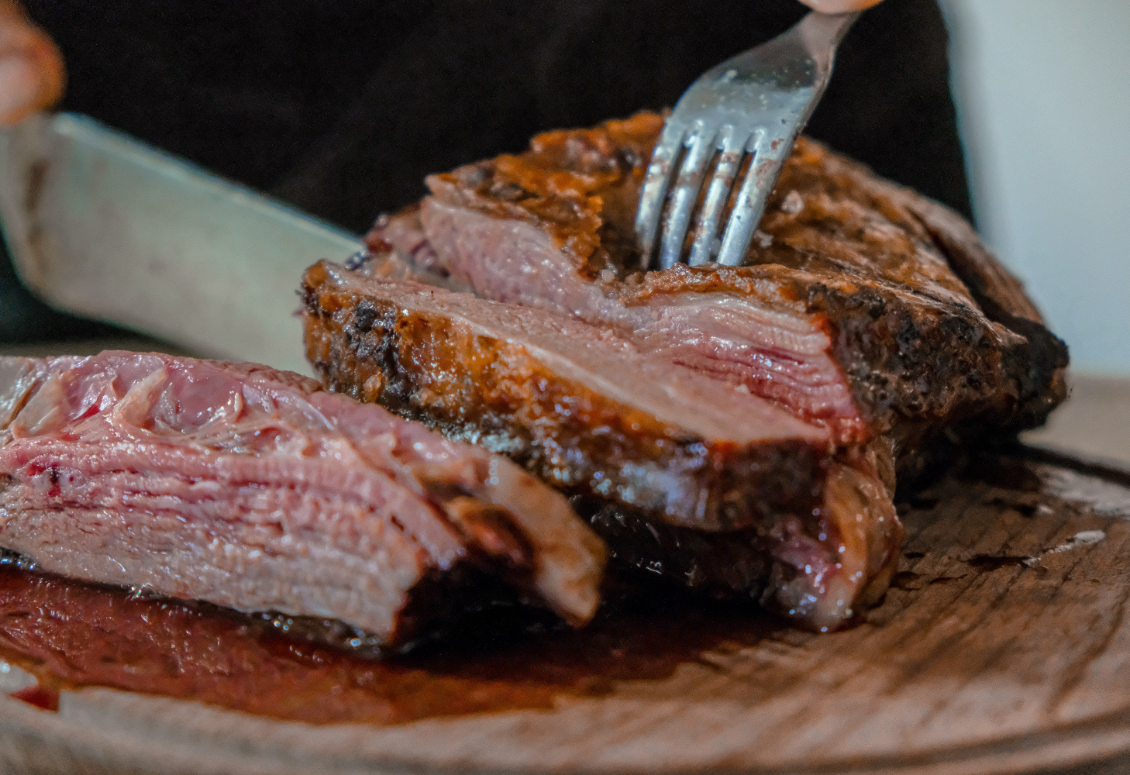 A person is cutting steak.