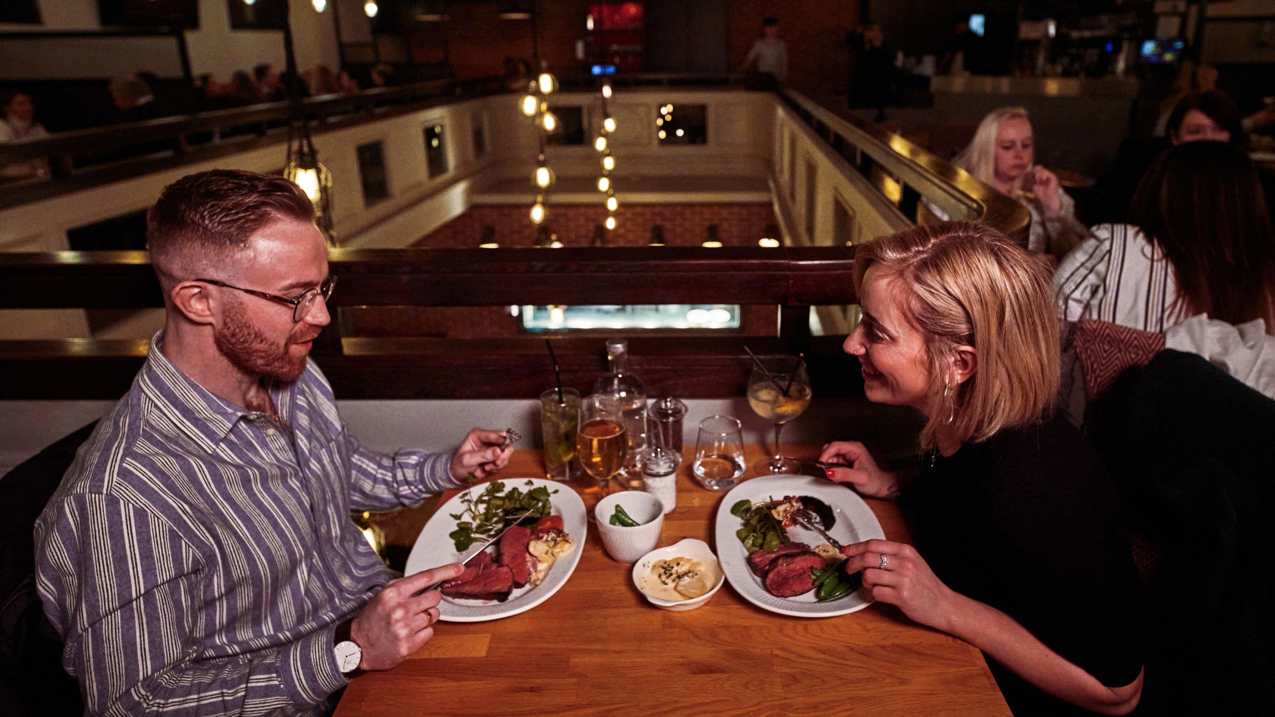 A couple is enjoying their meal and drinks in our restaurant.